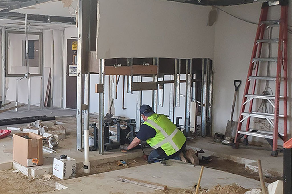 two construction workers working on an interior room
